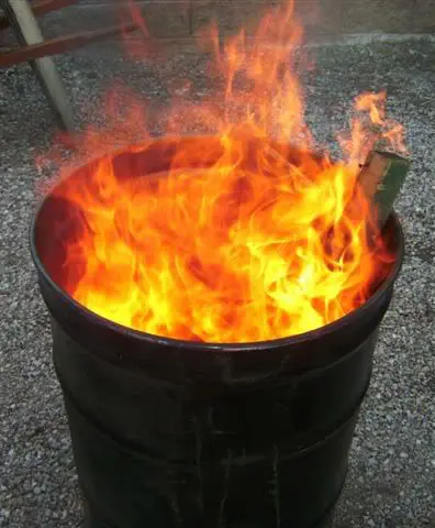 A burning fire inside a metal barrel.
