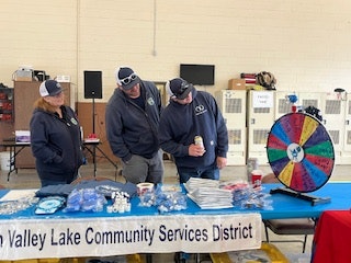 Three people looking at spinning wheel