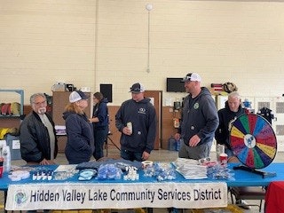 A group of people engaging at a table with promotional items for the Hidden Valley Lake Community Services District.
