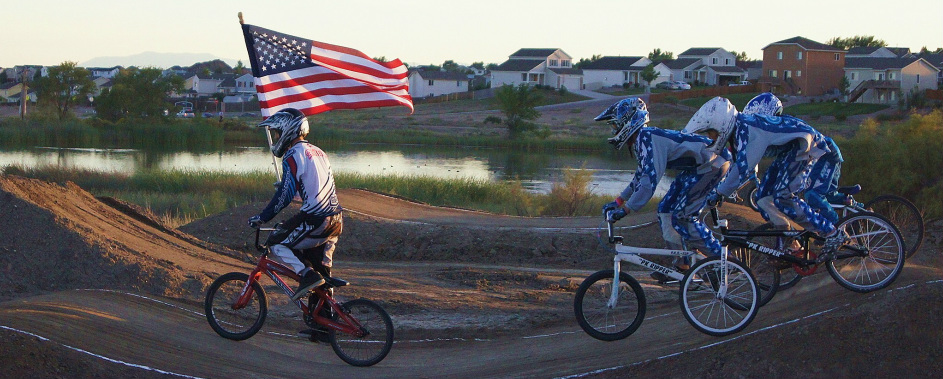 May contain: person, helmet, bicycle, transportation, vehicle, clothing, glove, and flag