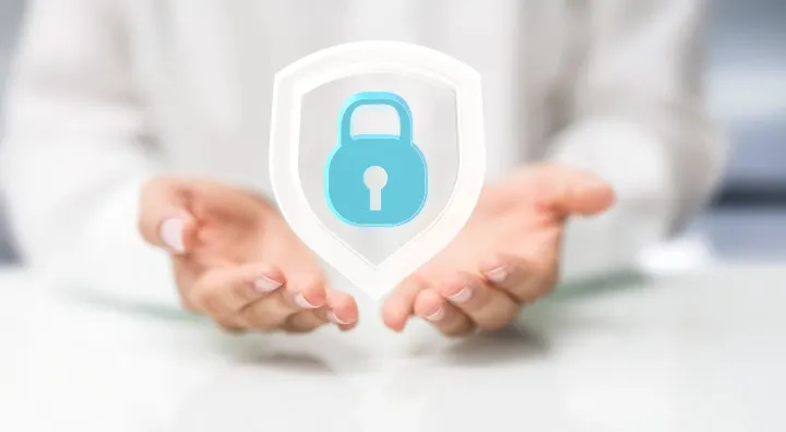 Hands holding a lock icon within a shield, symbolizing security or protection.