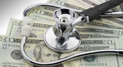 Stethoscope resting on a pile of U.S. twenty-dollar bills.