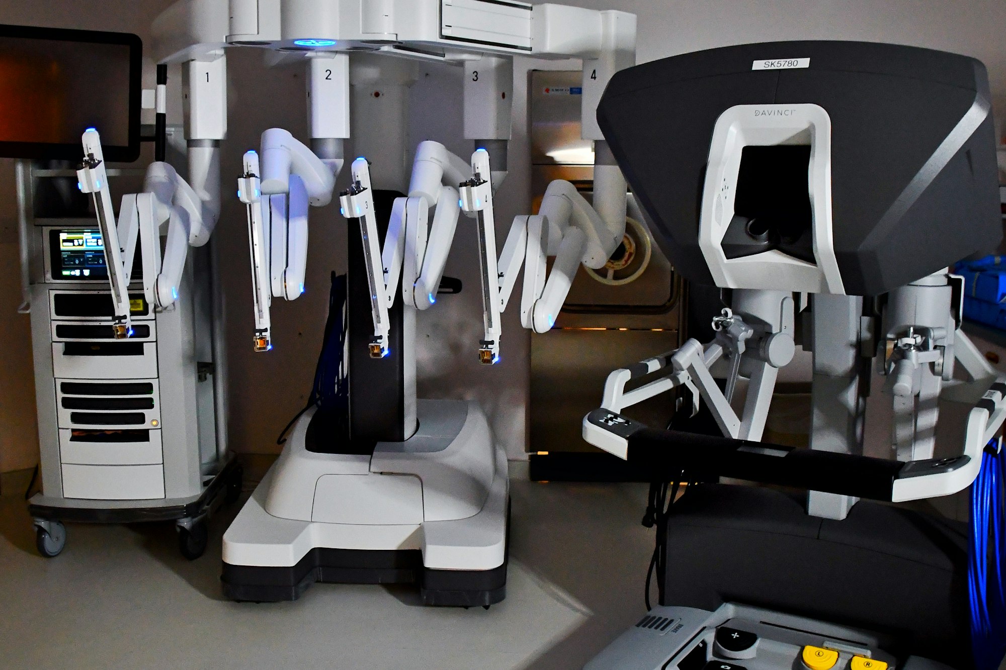 Robotic surgical system with multiple articulated arms and a control console.