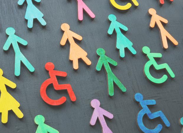 Colorful cutouts of people and wheelchair symbols are scattered on a dark background.