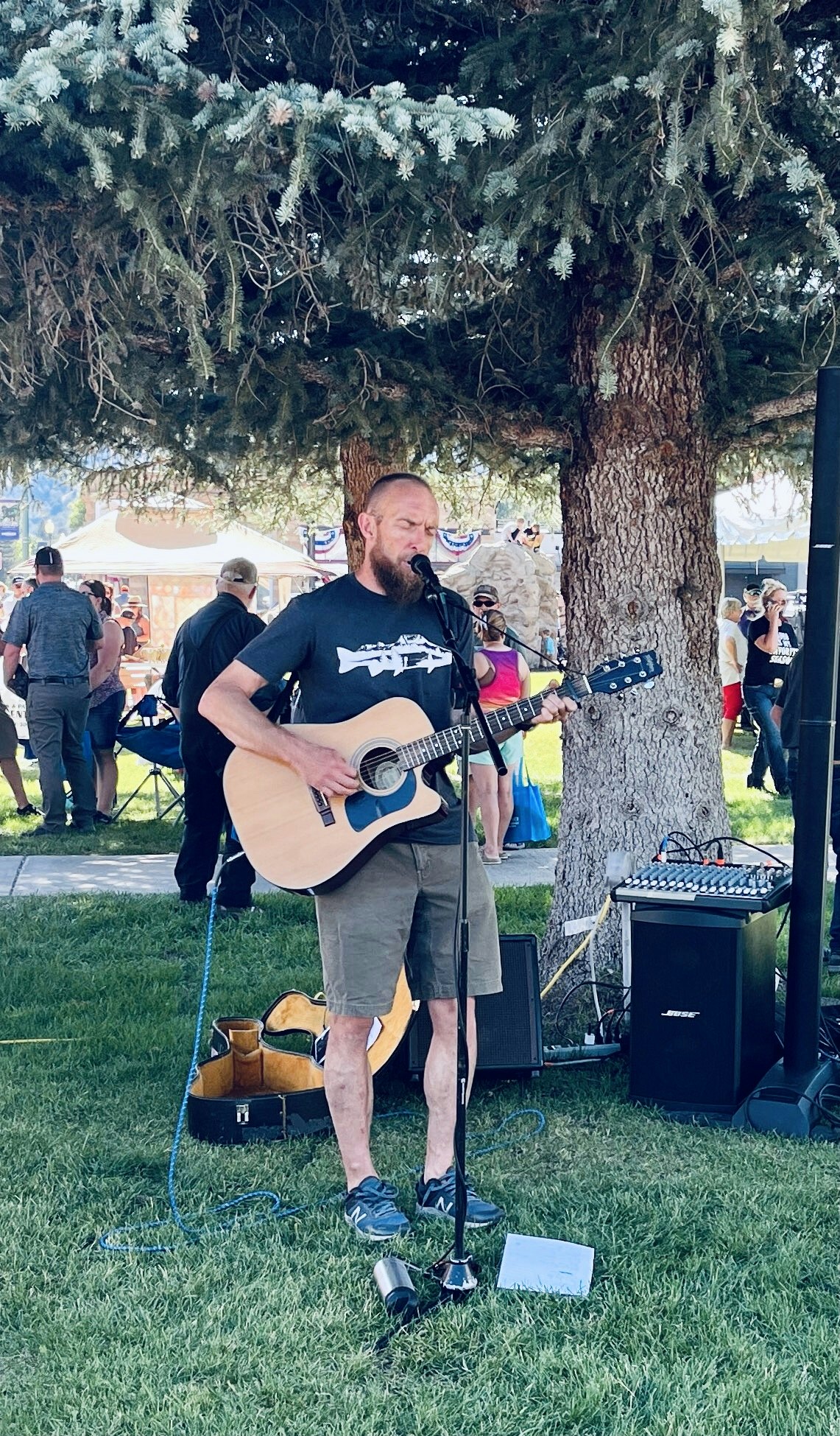 May contain: guitar, musical instrument, performer, person, solo performance, adult, male, man, guitarist, leisure activities, music, musician, accessories, bag, and handbag