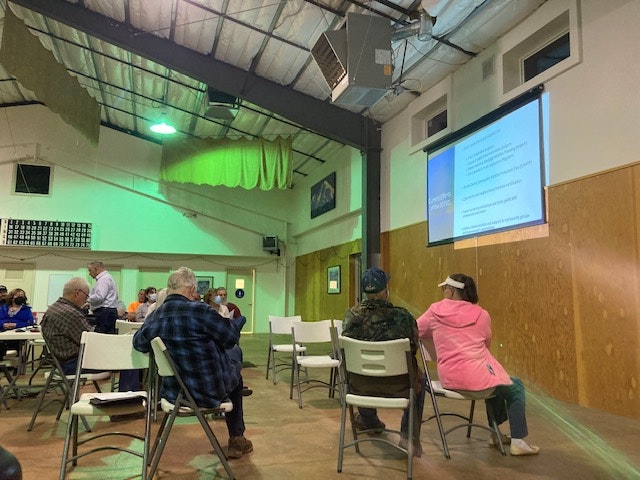 Community members meeting and viewing a presentation.