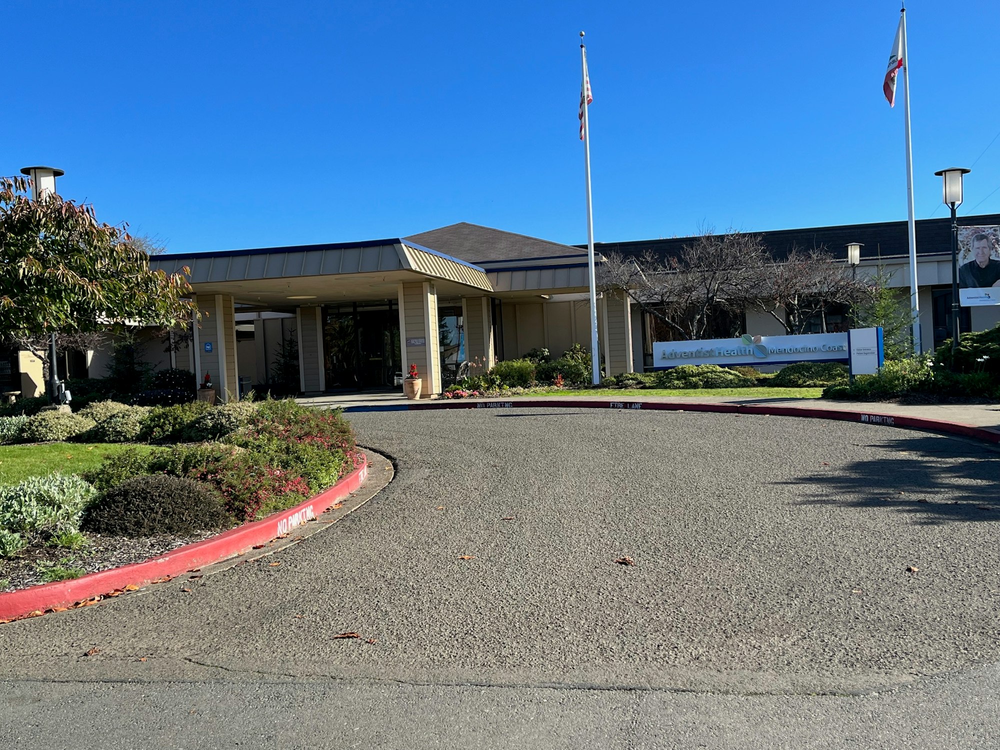 A healthcare facility with landscaped garden and clear skies.