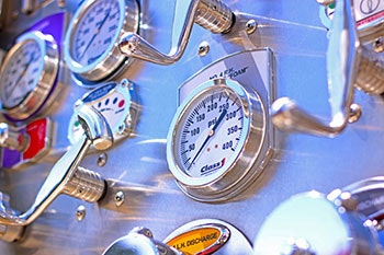 A close-up of several industrial gauges with dials and handles, possibly part of a machinery or control panel.