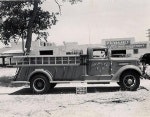 Vintage fire engine parked outdoors, black and white photo.