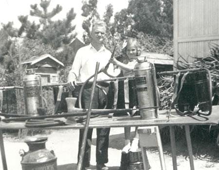 Two people with vintage beekeeping equipment.