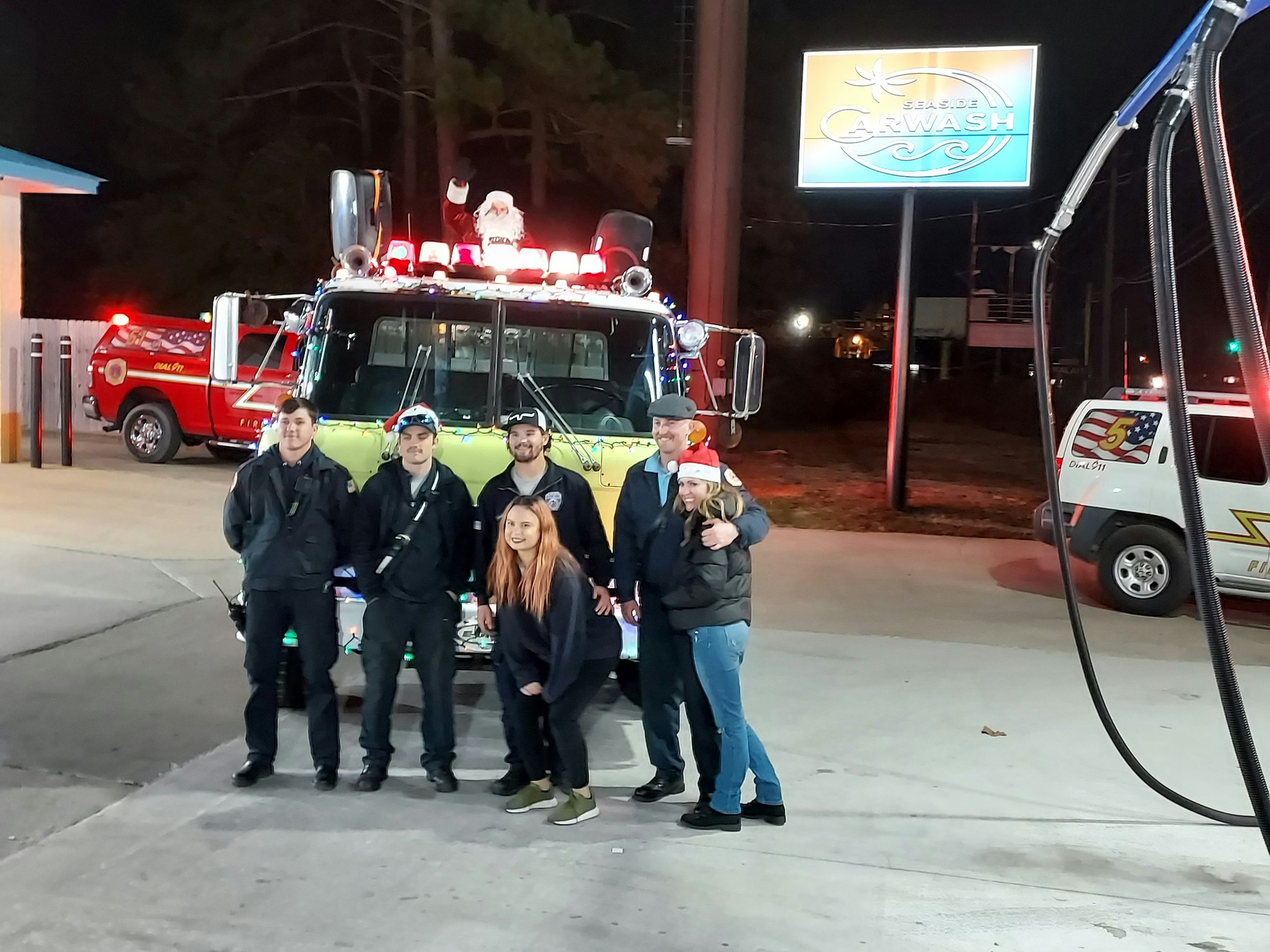 2021 Staff members posing with Santa during the annual Santa Run stop at Seaside Carwash.