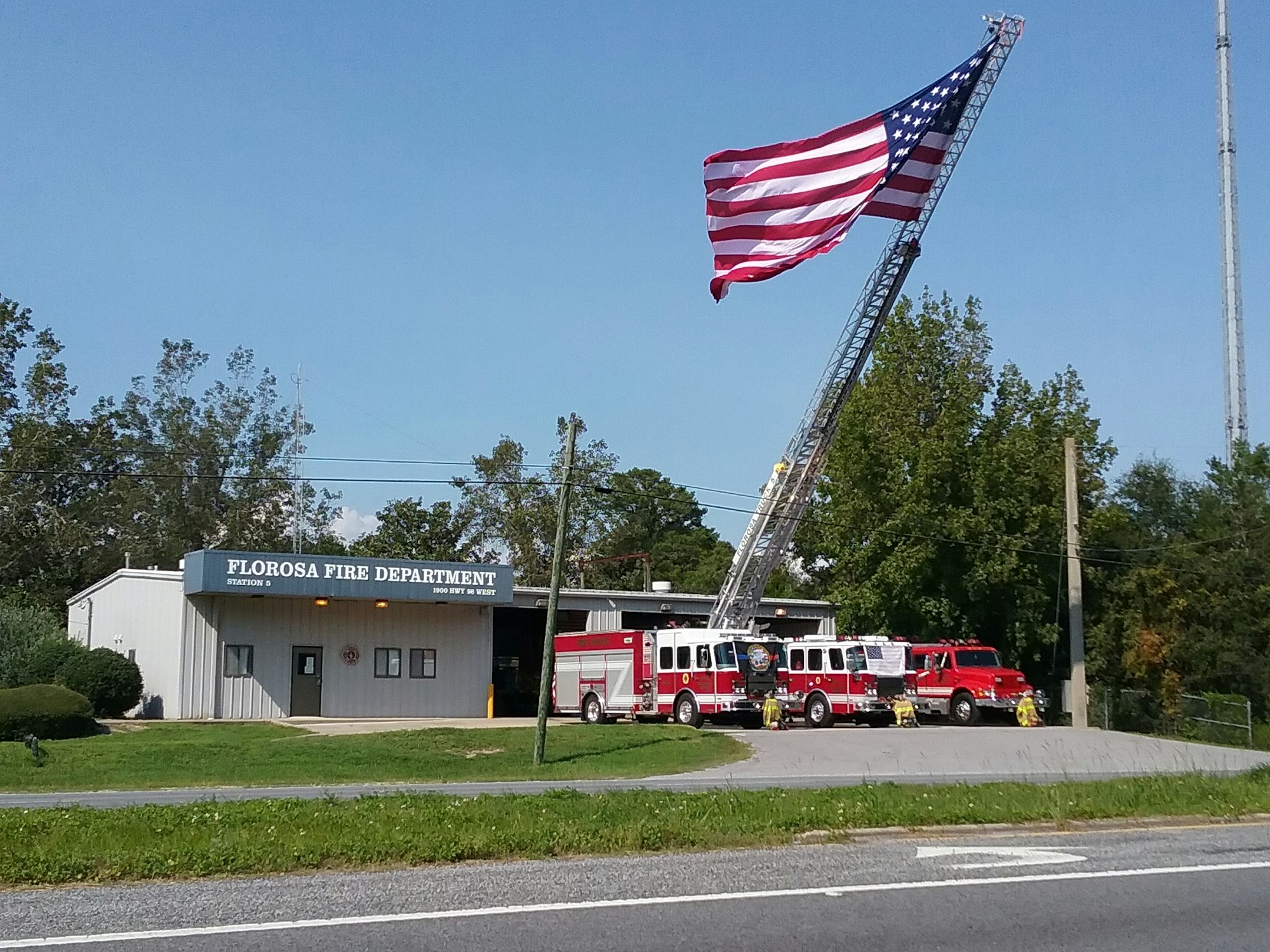 May contain: flag, fire truck, truck, vehicle, transportation, person, and fire station