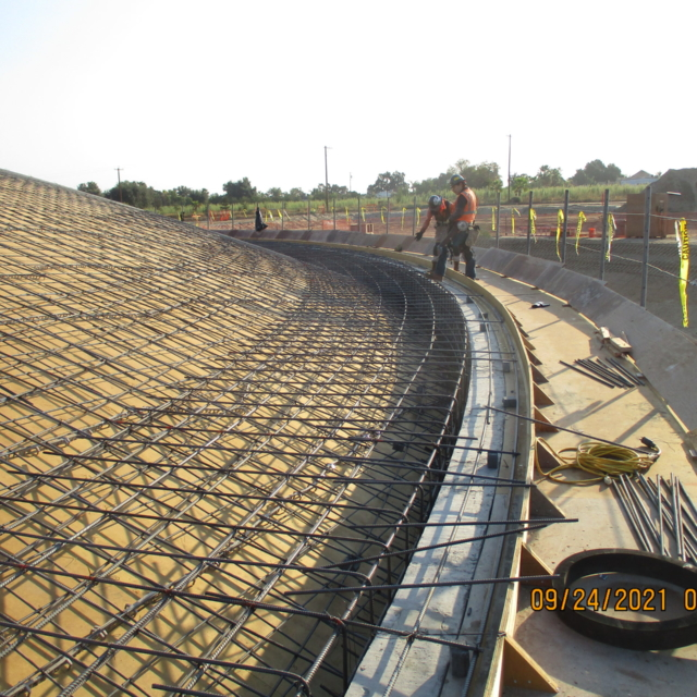 Construction site with steel rebar framework and workers.