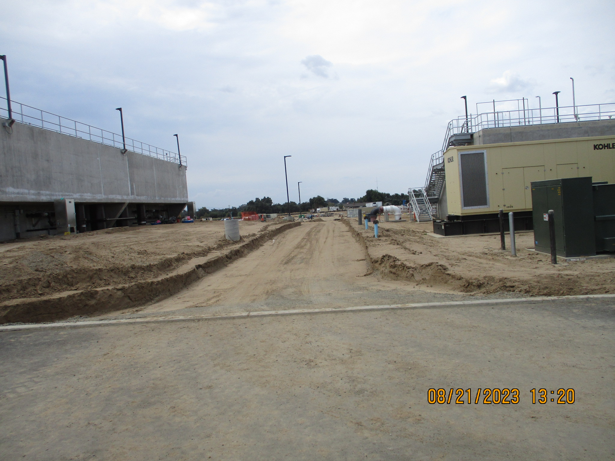 A construction site with sandy terrain and a large generator.