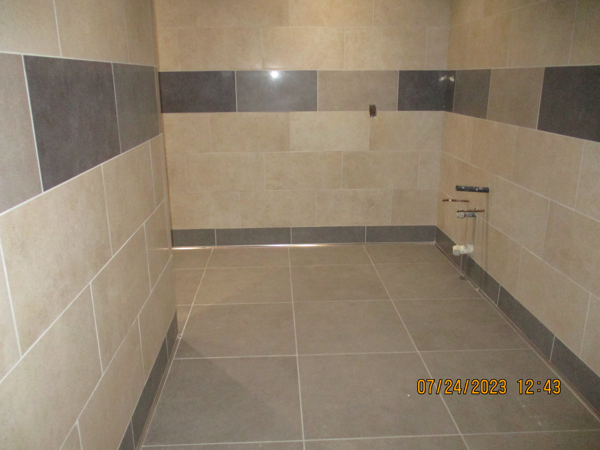 A tiled shower area with no showerhead or curtain yet, timestamped '07/24/2023 12:43'.