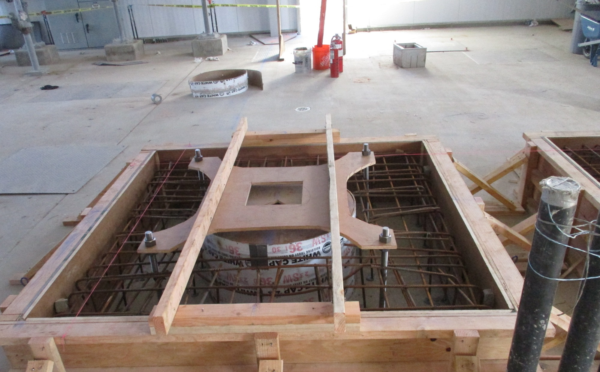 Construction site with wood forms and rebar, likely for a concrete foundation.