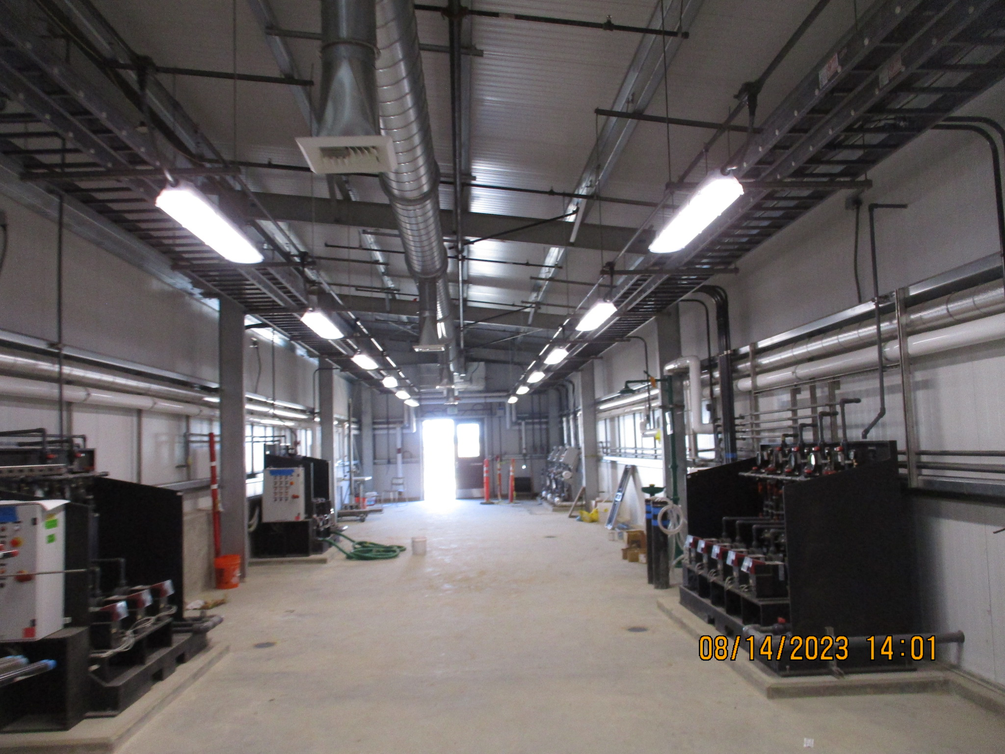 Industrial interior with piping, machinery, and bright lighting.