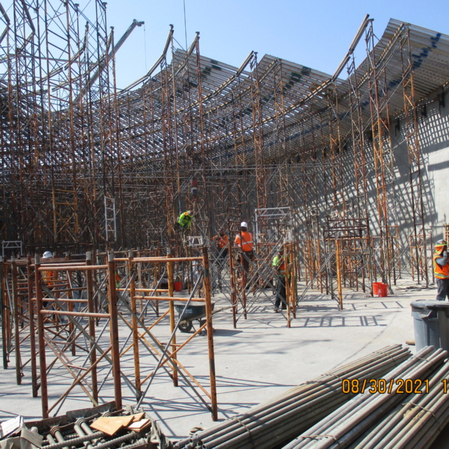Construction workers among extensive scaffolding at a building site.