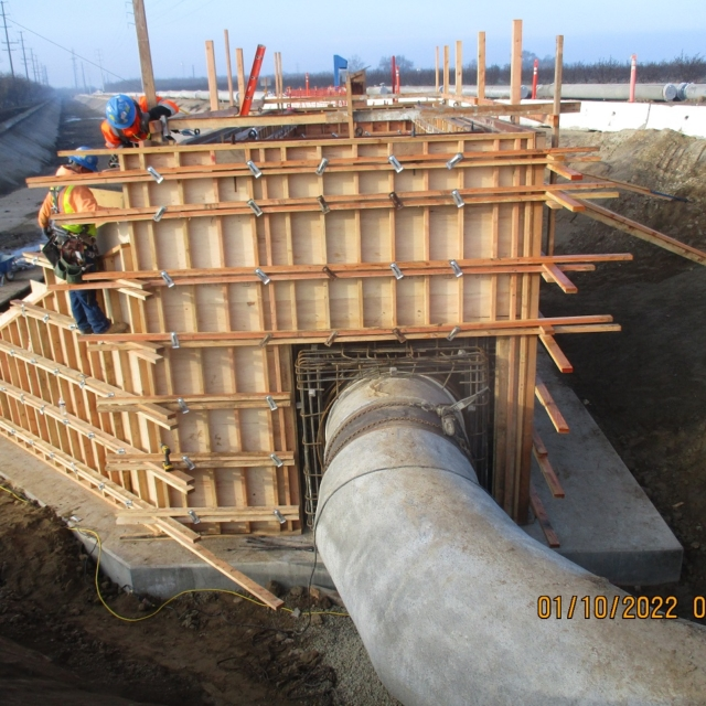 Construction site with wooden concrete forms and workers.