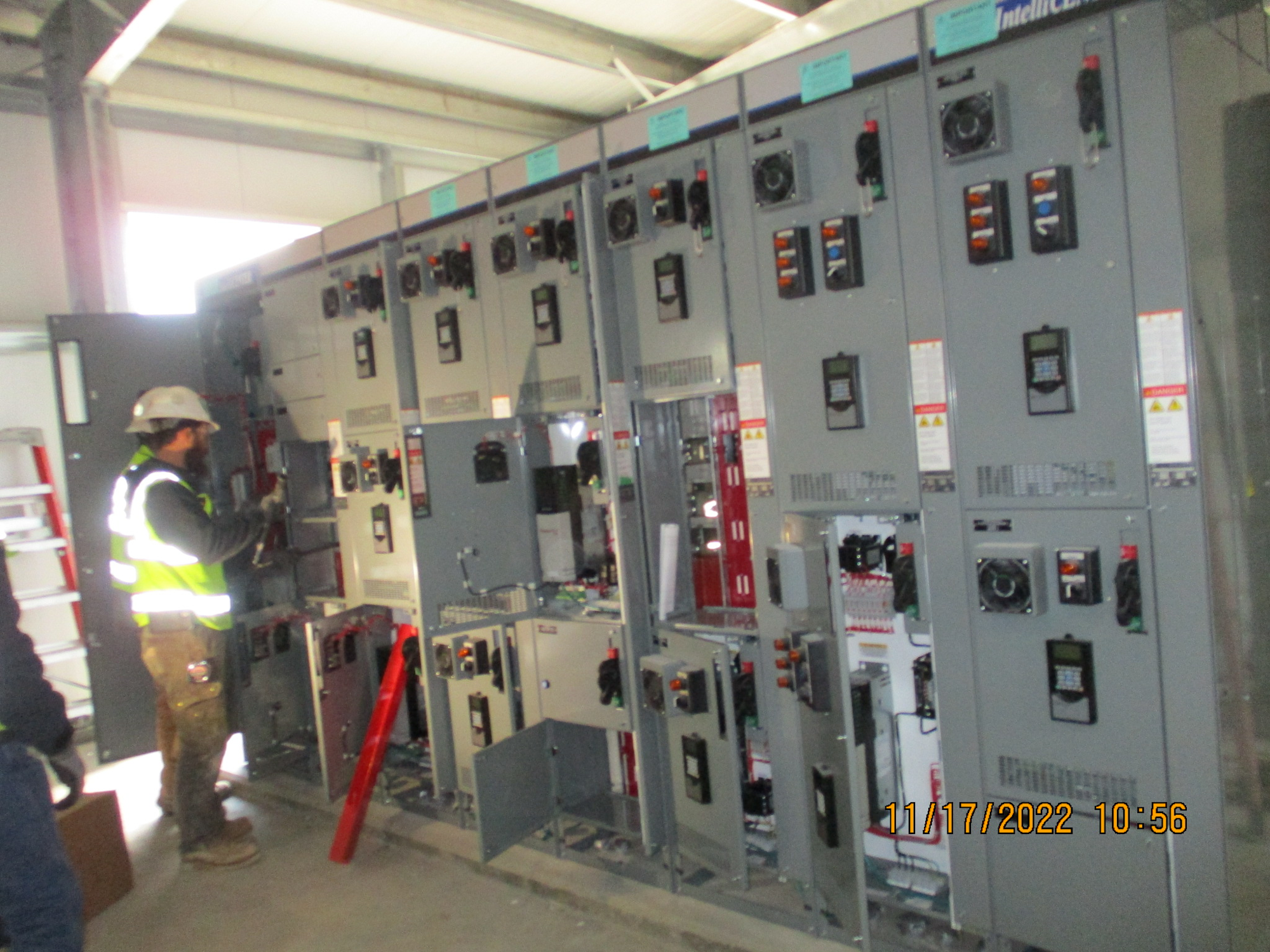 A worker inspects electrical panels.