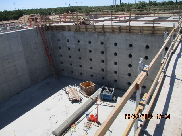 A construction site with concrete walls, building materials, and a date stamp indicating June 29, 2022.