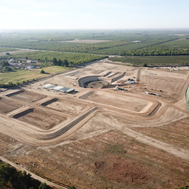 An aerial view of a construction site with excavated areas and heavy machinery.