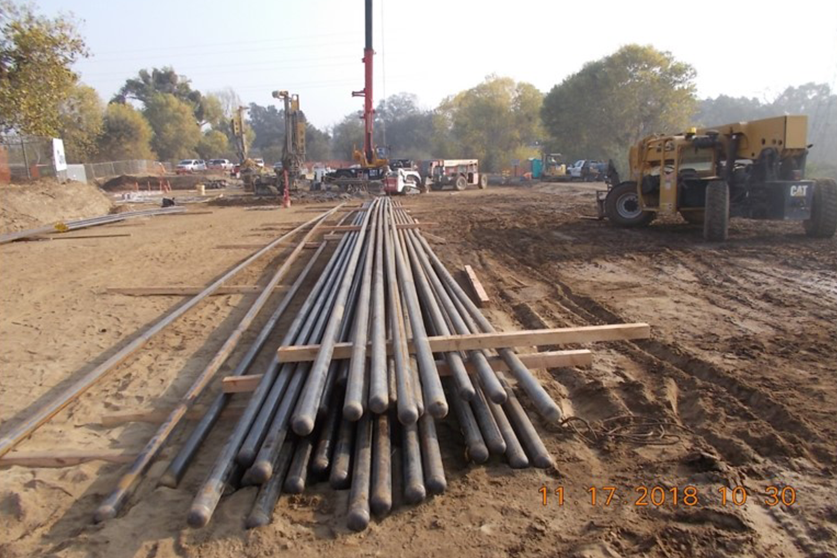 A construction site with metal pipes and heavy machinery.
