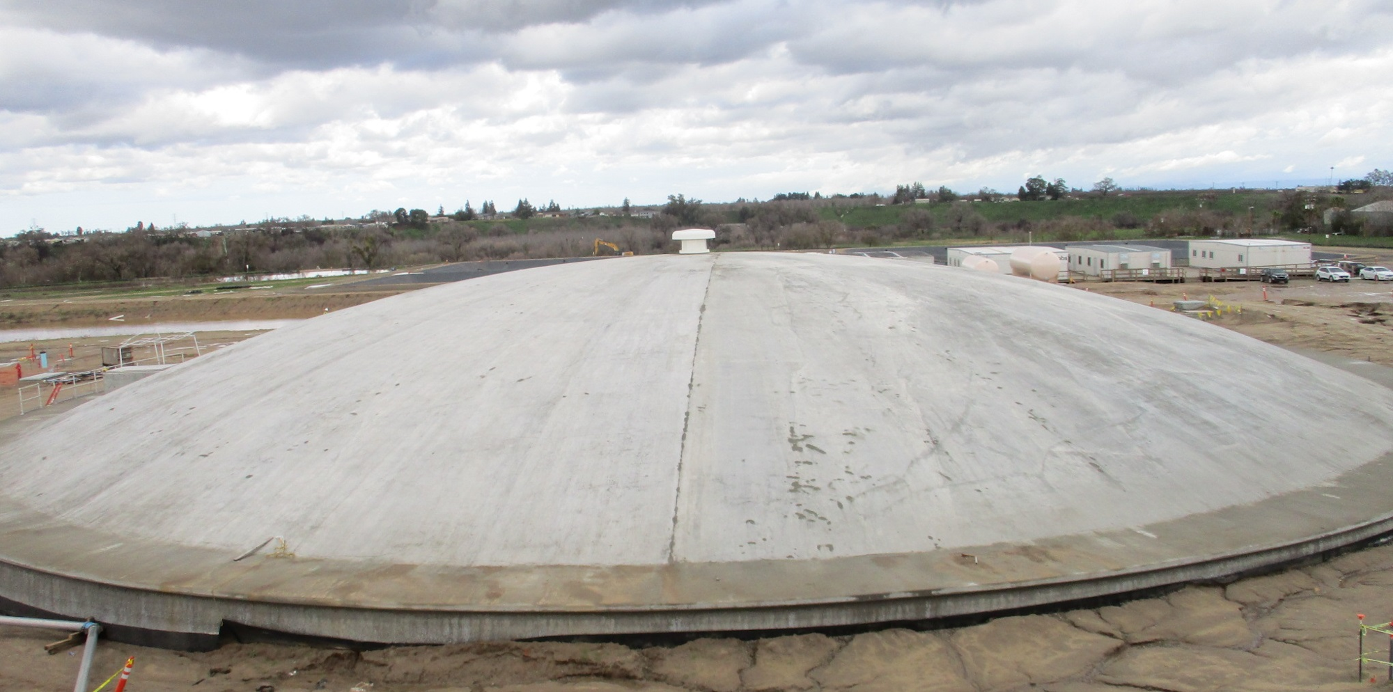 Large dome structure, possibly a storage facility, with industrial surroundings and cloudy skies above.