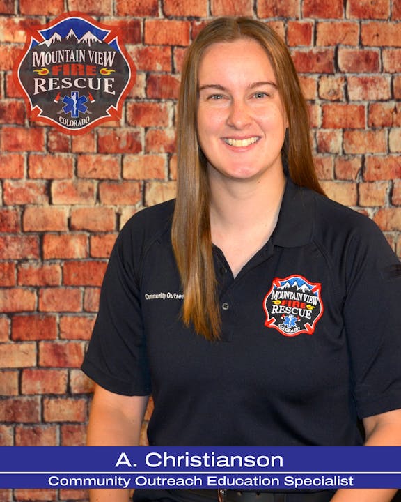 A smiling person in a uniform with a badge "Mountain View Fire Rescue Colorado," titled as a Community Outreach Education Specialist.