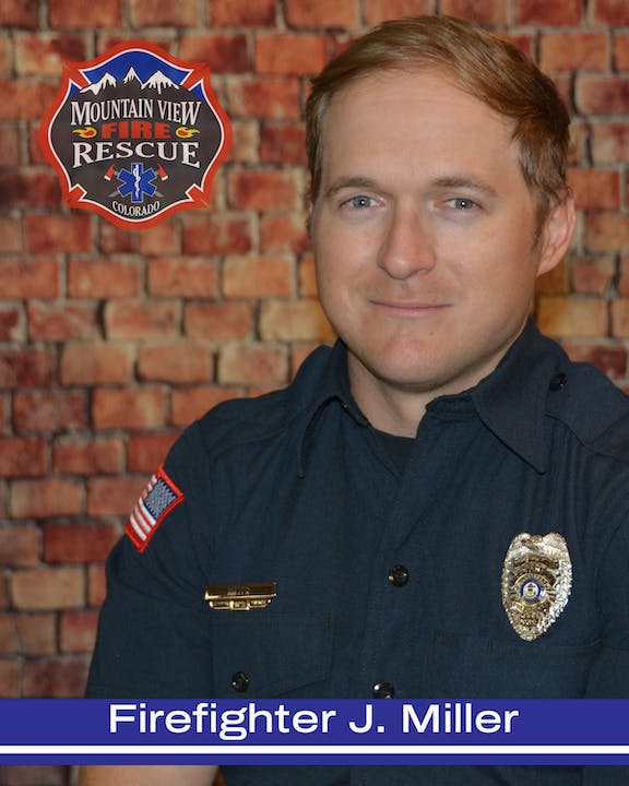 A smiling firefighter in uniform, with a badge and a patch that reads "Mountain View Fire Rescue Colorado."