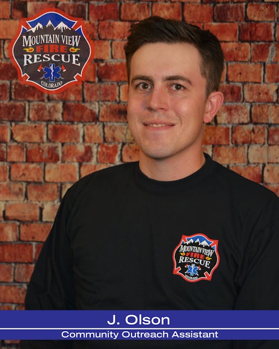 A person with a badge from "Mountain View Fire Rescue Colorado" stands against a brick wall backdrop.