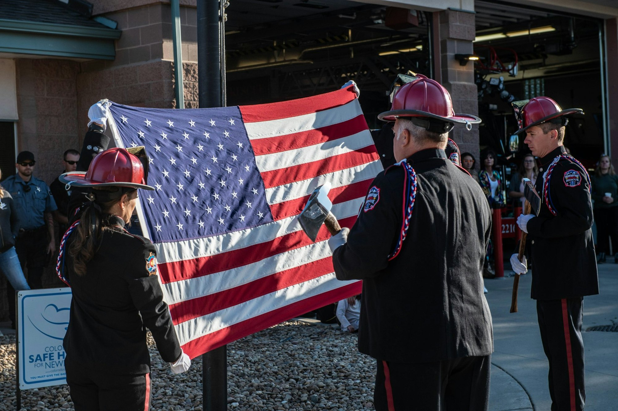 May contain: person, human, clothing, apparel, helmet, flag, symbol, and hardhat