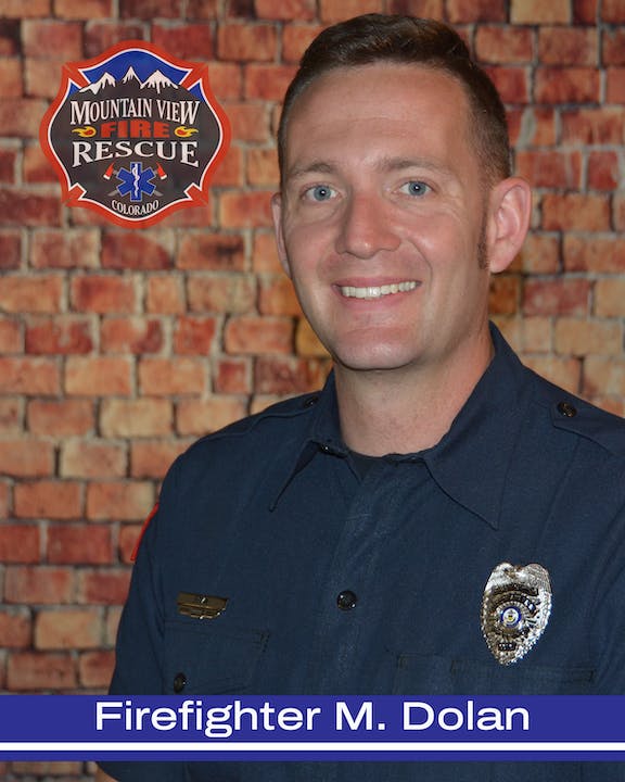 A firefighter named M. Dolan from Mountain View Fire Rescue in Colorado, standing in front of a brick wall.