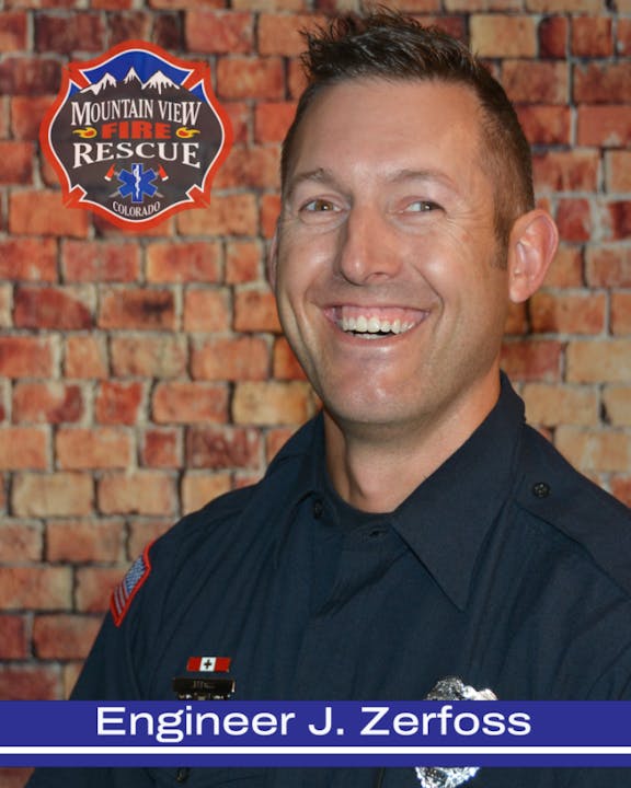 A smiling person in a firefighter uniform with a badge that says "Engineer J. Zerfoss" from Mountain View Fire Rescue, Colorado.