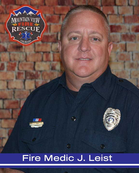 A portrait of a fire medic in uniform with badges and a logo of Mountain View Fire Rescue, Colorado.