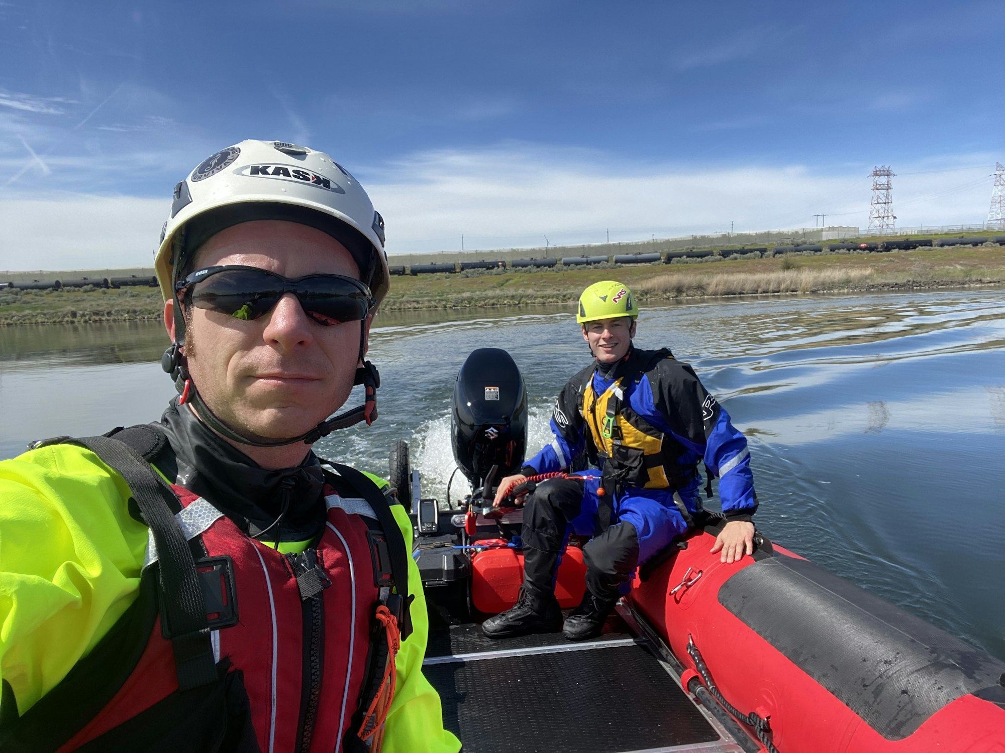 May contain: clothing, vest, lifejacket, helmet, adult, male, man, person, accessories, glasses, footwear, shoe, hardhat, boat, transportation, and vehicle