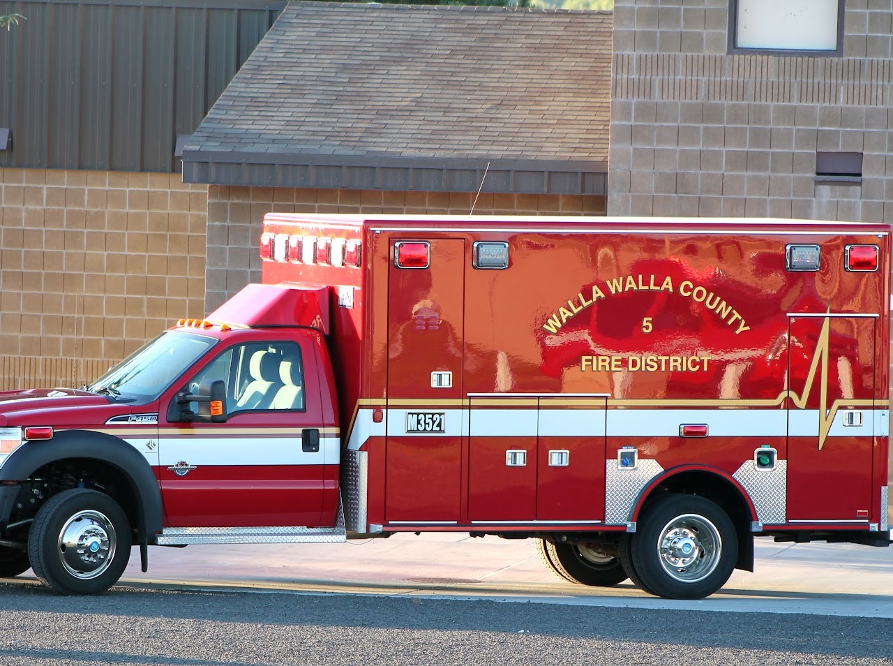 The image shows a red ambulance marked with "Walla Walla County Fire District 5," parked outside a building.