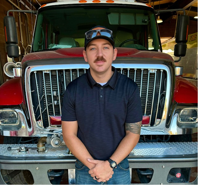A person standing in front of a red and white firetruck.