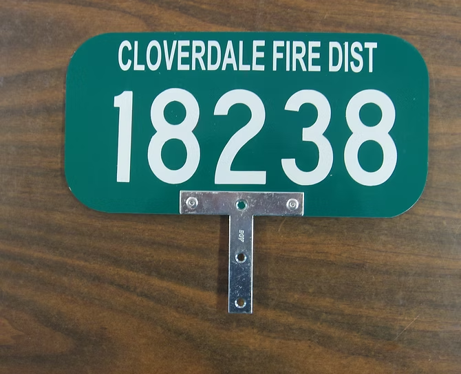 Green sign reading "CLOVERDALE FIRE DIST 18238" with mounting bracket.
