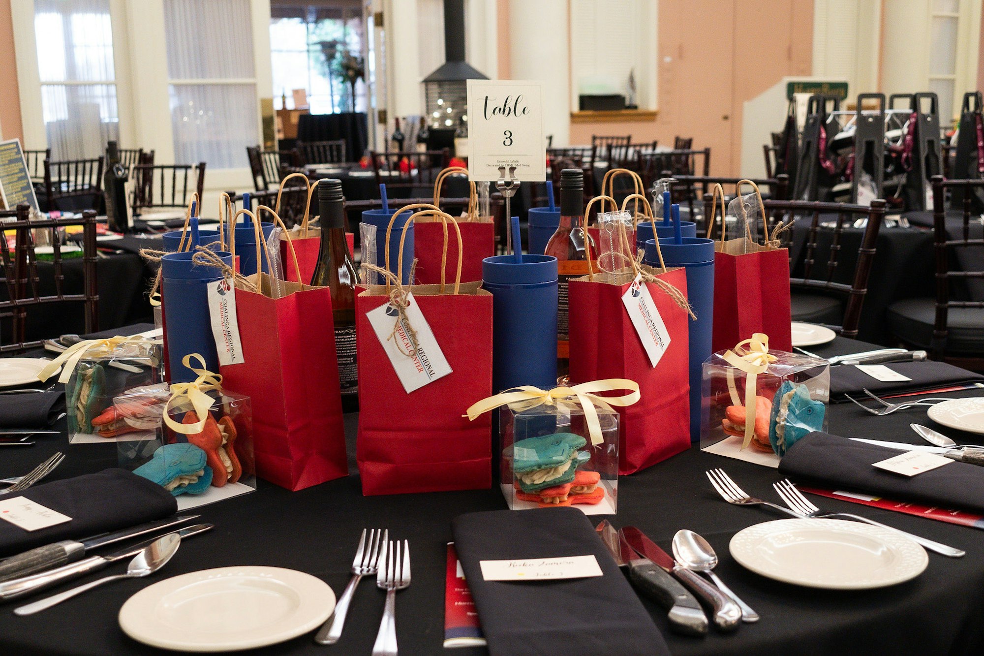 Elegantly set dining tables with gift bags and cookie favors for a planned event.