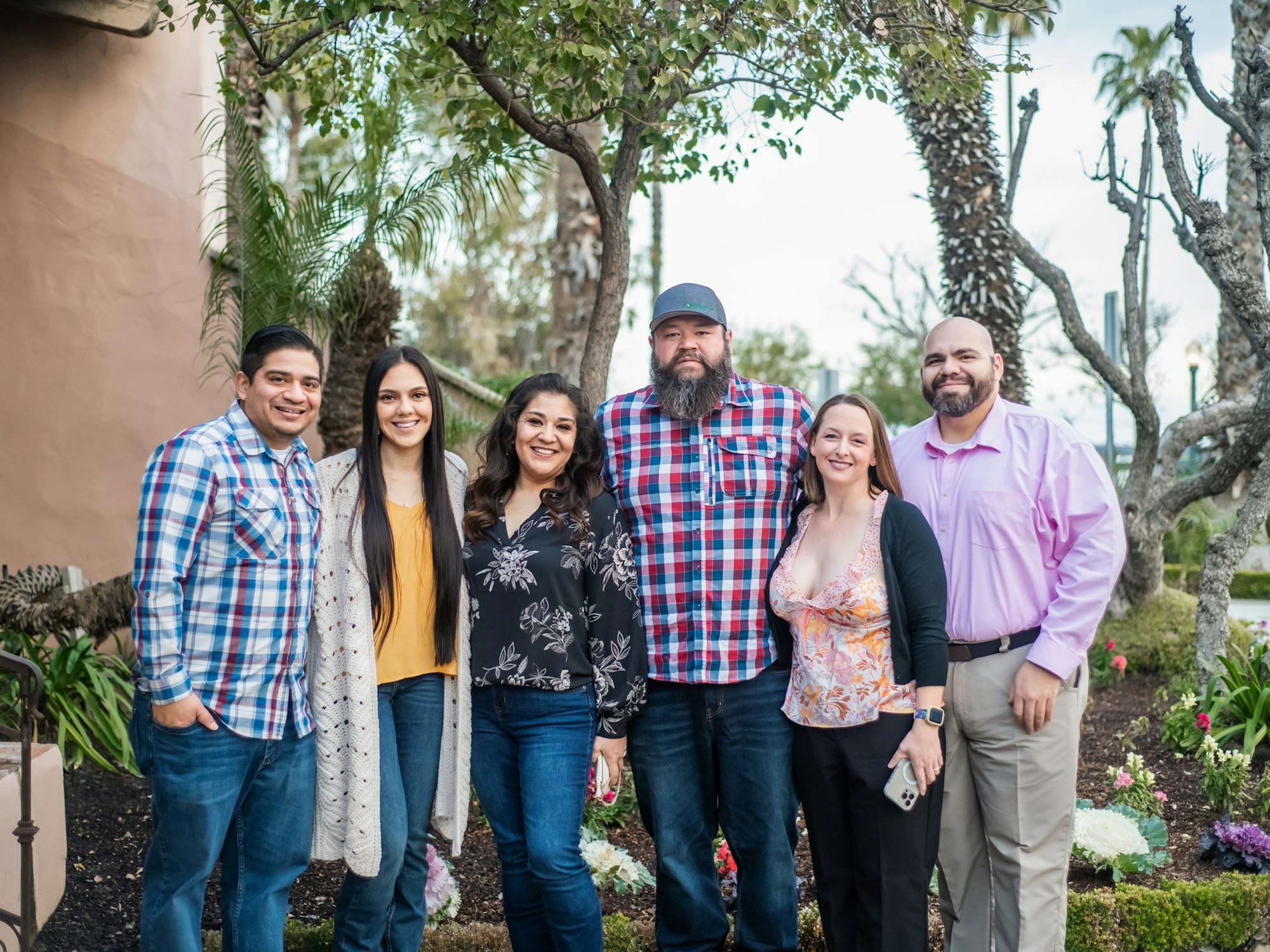 May contain: clothing, pants, people, person, female, girl, teen, jeans, blouse, wristwatch, groupshot, face, happy, head, smile, adult, woman, male, man, accessories, belt, plant, tree, photography, portrait, hat, and shirt