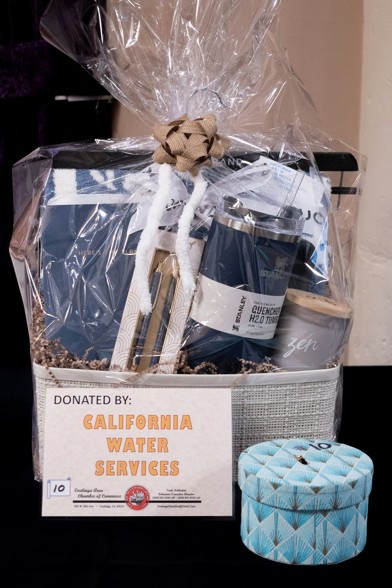 Gift basket with a variety of items, wrapped in clear plastic, donated by California Water Services.