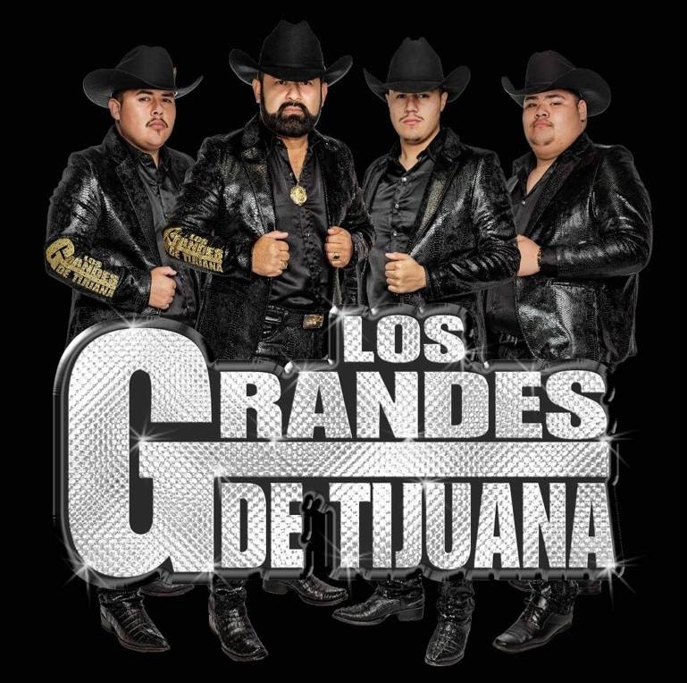 The image features a music group called "Los Grandes de Tijuana," showcasing four members in stylish outfits and hats.