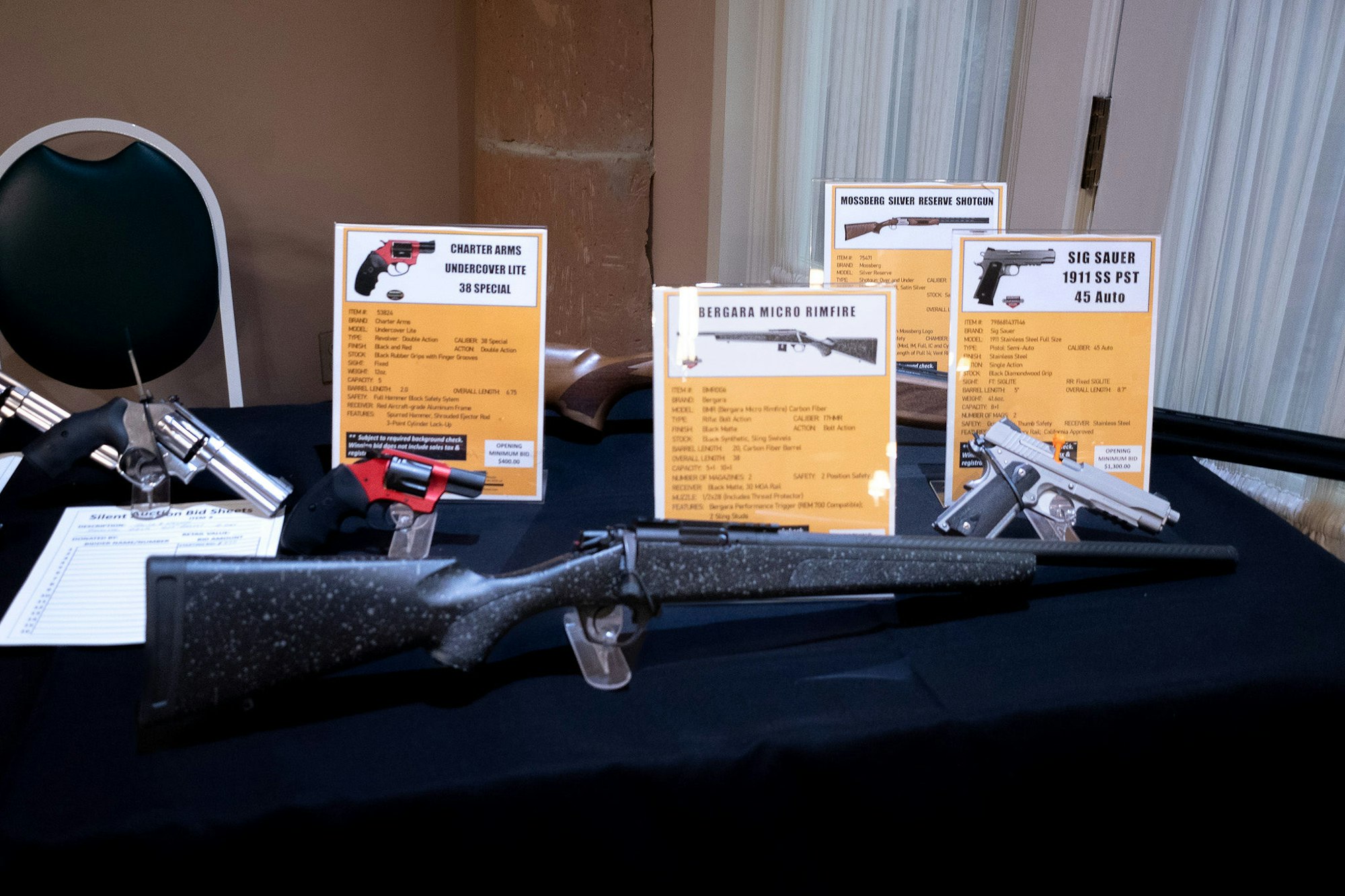 A display table with firearms and informational cards.