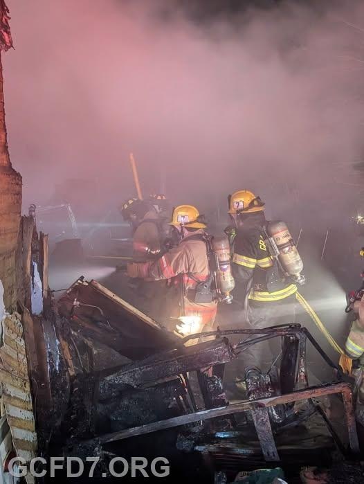 Firefighters are battling a blaze, with smoke filling the area as they work on the scene.