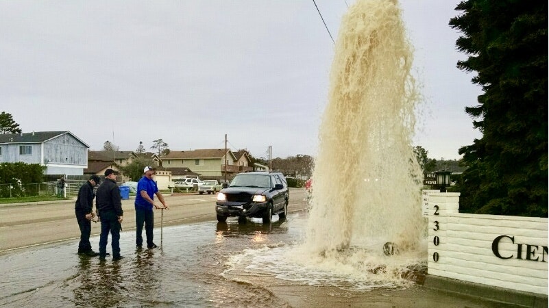 May contain: neighborhood, person, car, transportation, vehicle, water, car wash, pickup truck, truck, city, clothing, hat, road, street, and urban