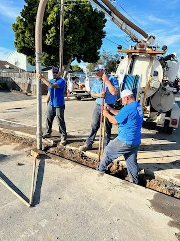 May contain: person, worker, clothing, pants, utility pole, city, road, street, and urban