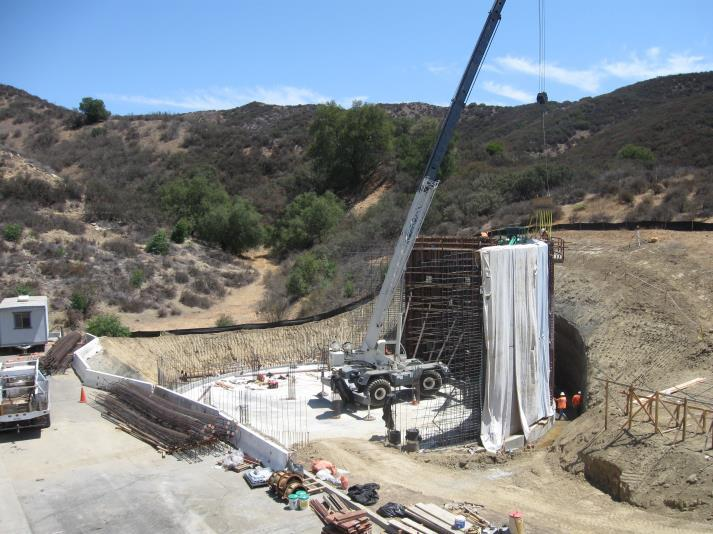 A construction site with a crane and workers in a desert-like landscape.