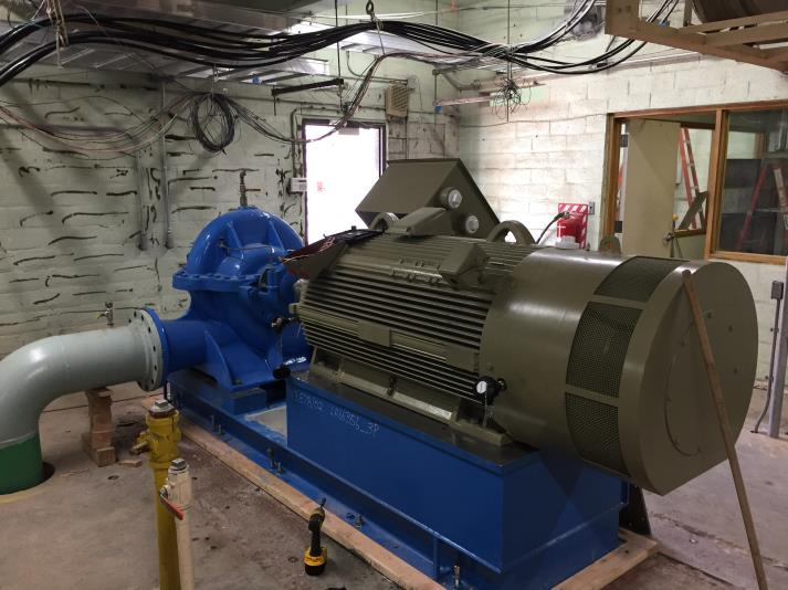 Industrial pump and motor setup in a facility, with cables and pipes.