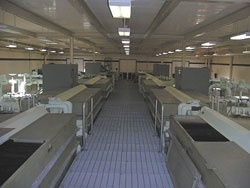 A factory or industrial setting with large metal machines lined up in a spacious room.